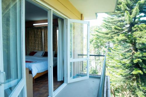 eine Glastür, die zu einem Schlafzimmer mit einem Bett führt in der Unterkunft Holiday Home near Swayambhunath Stupa in Kathmandu