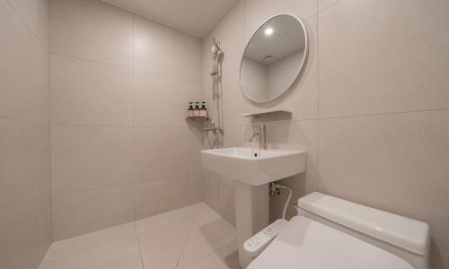 uma casa de banho com um lavatório, um WC e um espelho. em Annk Hotel Daejeon Daeheung em Daejeon