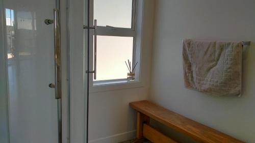 a bathroom with a shower and a towel on a window at Lake Tekapo Double Room shared facilities in Lake Tekapo
