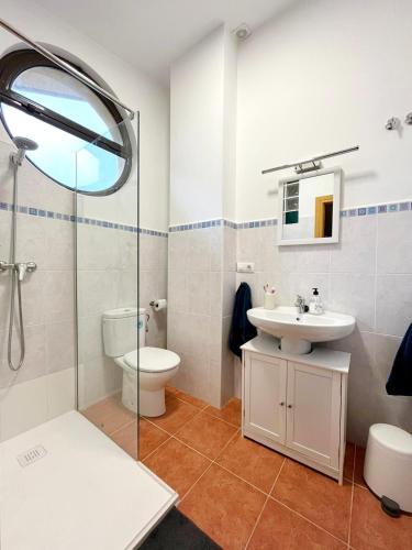a bathroom with a sink and a toilet and a shower at Dúplex El refugio de Porma in Puebla de Lillo