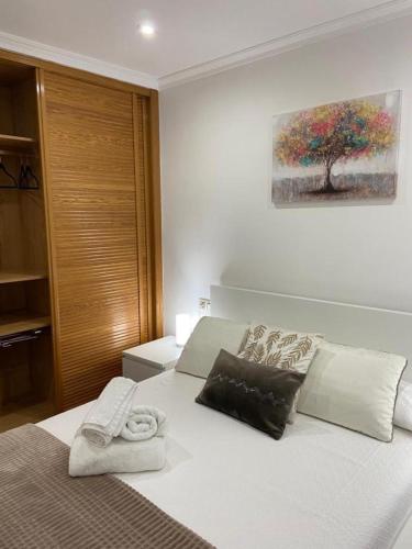 ビーゴにあるPreciosa casa en Bembriveの白いベッド1台付きのベッドルーム1室(壁に木の絵が描かれた)