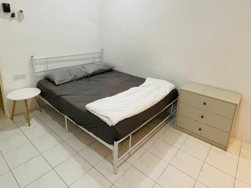 a small bedroom with a bed and a night stand at haus_22 in Bukit Mertajam