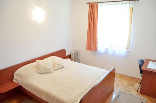 a bedroom with a bed with two pillows on it at Apartment Evropa in Zlatibor