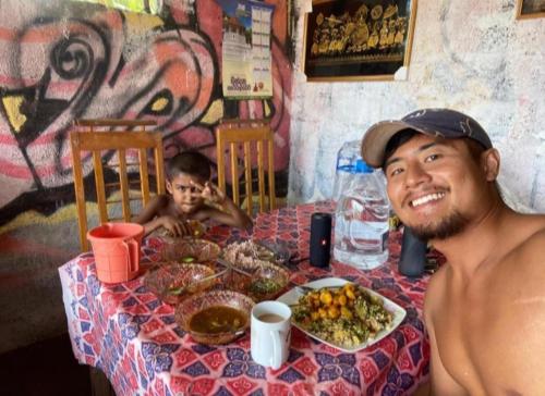 ウェリガマにあるSandaru Surffing Innの食卓に座る男