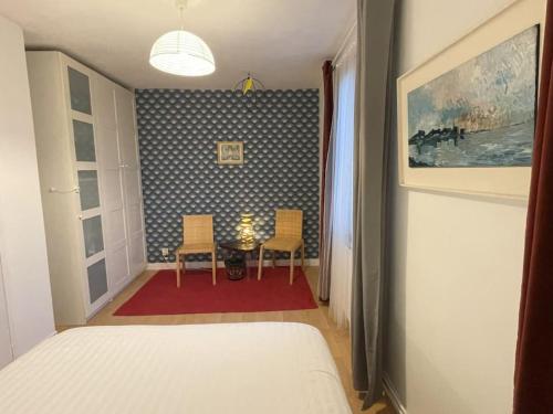 a bedroom with a table and two chairs in a room at Maison de Charme 95m2 à Saint-Denis PLEYEL, 4 Chambres, Terrasse, Calme, Proche Paris et Stade de France in Saint-Denis