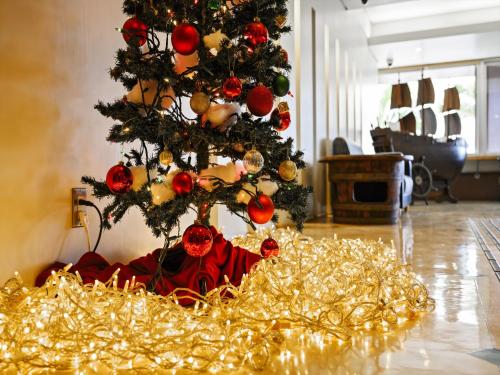 a christmas tree in a living room with gold lights at Hotel Sunset Terrace in Chatan