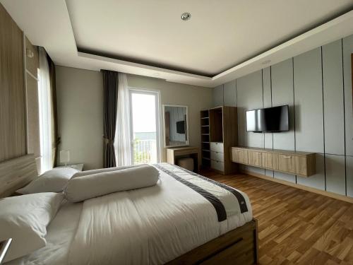 1 dormitorio con 1 cama grande y TV en Valle Verde Villas en Bandung