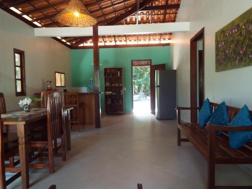 a dining room with a table and a refrigerator at Casa Malibu in Ilha de Boipeba