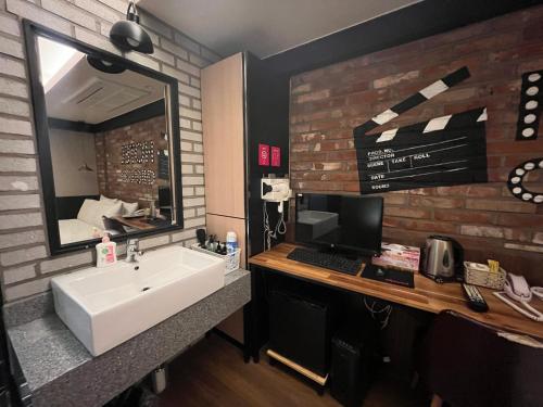 a bathroom with a sink and a computer on a counter at D Well Hotel in Busan