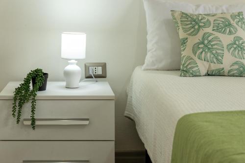 a bed with a night stand with a lamp on it at Casa Belvedere in Codrongianos