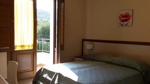 パリヌーロにあるResidence Sophoraのベッドルーム1室(ベッド1台付)、バルコニーへのドアが備わります。