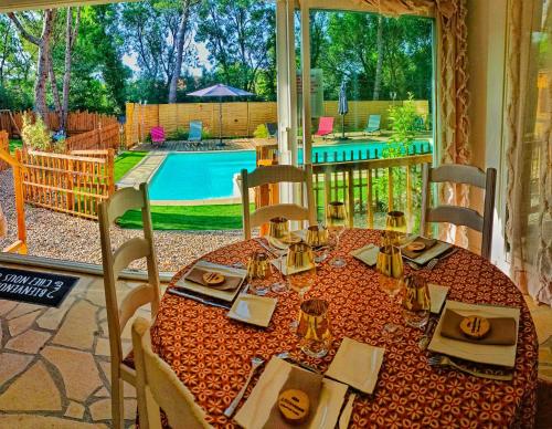 uma sala de jantar com uma mesa e vista para uma piscina em L'Entre-Nous Carcassonne em Carcassonne