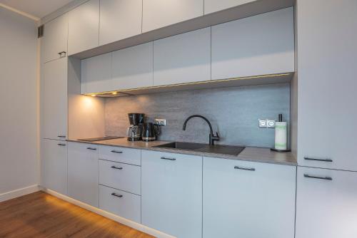 a kitchen with white cabinets and a sink at Widok 3B/6 in Piechowice