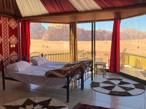 una camera da letto con un letto e una grande finestra di Bedouin Tours Camp a Wadi Rum