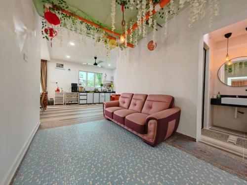 - un salon avec un canapé au milieu d'une pièce dans l'établissement VegeGarden Cozy Home @Ipoh Town Center, à Ipoh