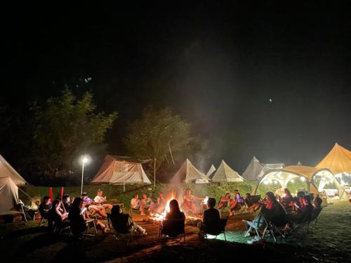 a group of people sitting around a fire at night at Camping Núi Thủng ở Cao Bằng in Cao Bằng