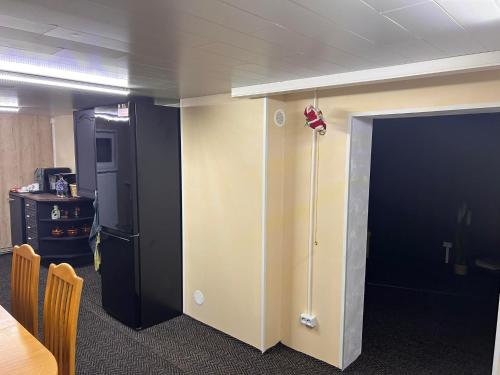 an office with a black door and a black refrigerator at Valgemaja Majutus in Restu