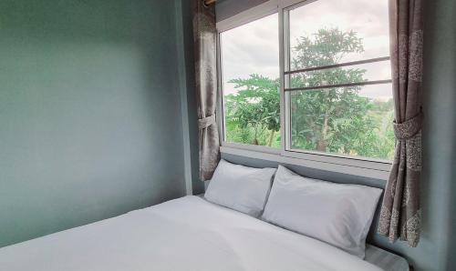 a bed in a room with a window at Blessing Pua in Ban Lao