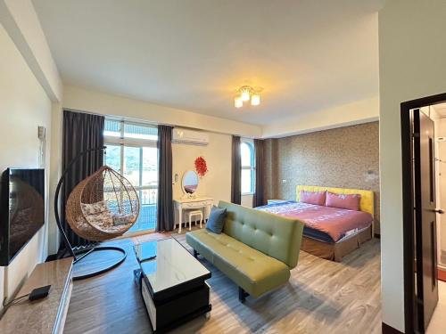 uma sala de estar com um sofá e uma cama num quarto em Holiday Homestay em Chishang