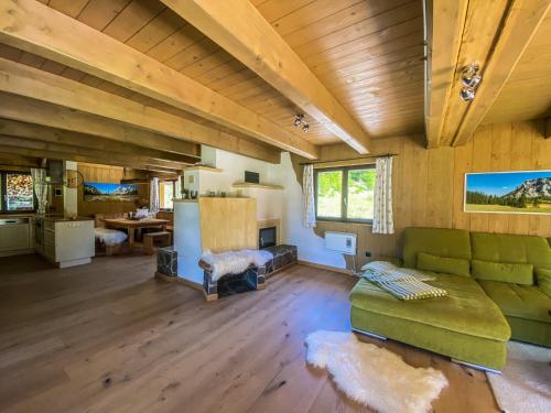 a living room with a green couch and a kitchen at Chalet Wildalpen (in Ruhelage & mit Wellness) in Wildalpen