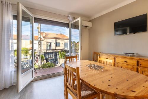 une salle à manger avec une table et une grande fenêtre dans l'établissement Mandarine - Appt à 10min d'Argelès-Sur-Mer, à Saint-André