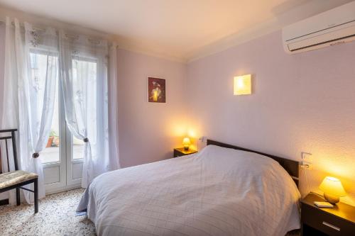 ein Schlafzimmer mit einem weißen Bett und einem Fenster in der Unterkunft Pamplemousse - Appt à 10min d'Argelès-Sur-Mer in Saint-André