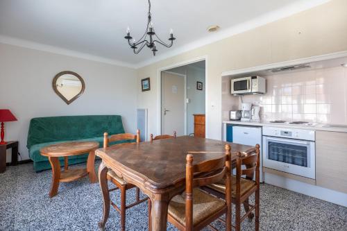 une cuisine et une salle à manger avec une table et des chaises en bois dans l'établissement Orange - Appt à 10min d'Argelès-Sur-Mer, à Saint-André
