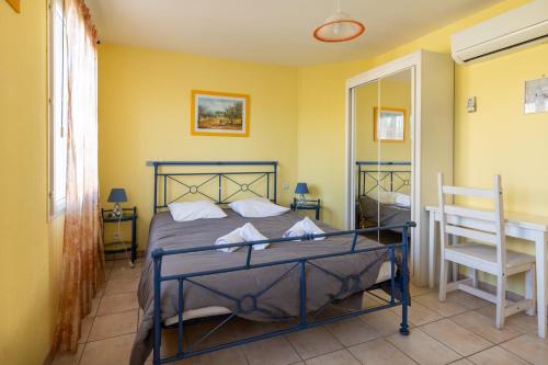 een slaapkamer met een bed, een bureau en een stoel bij Maison des Vignes - 7 chambres in Saint-André