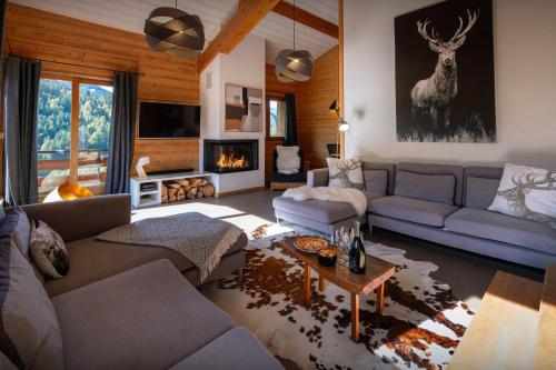 a living room with a couch and a fireplace at Chalet Paravis - OVO Network in La Clusaz