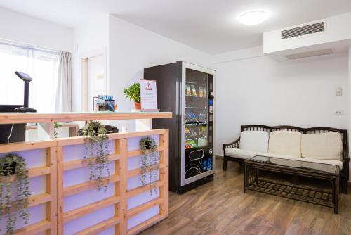 una camera con due sedie bianche e un refrigeratore per bevande di Aurora Rooms - 290m from Aqua Park a Băile Olăneşti
