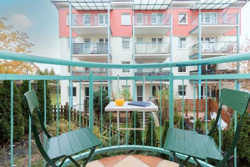 a balcony with two chairs and a table and a building at Subtle and Cosy Studio with Furnished Balcony in Gdańsk by Renters in Gdańsk