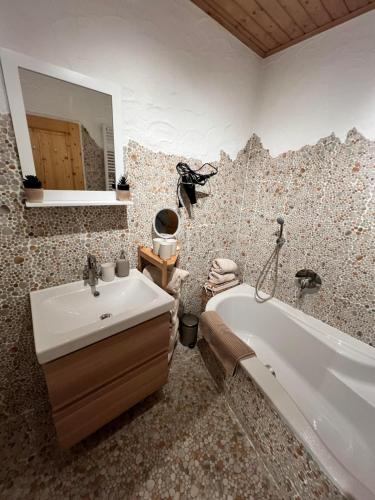 a bathroom with a sink and a tub and a mirror at Hanna's Home in Kitzbühel