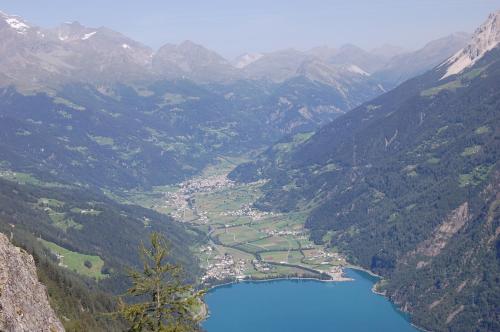 a view of a mountain valley with a blue lake at B&B Alpina in Le Prese