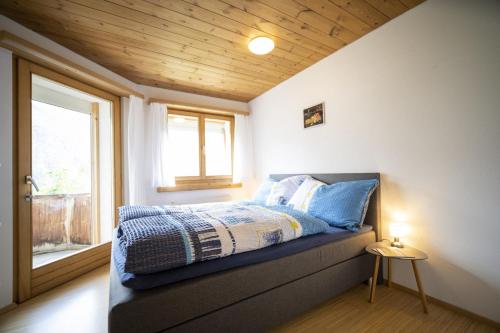 a bedroom with a bed with a window at Chasa Tanter Vias - Capricorn in Scuol