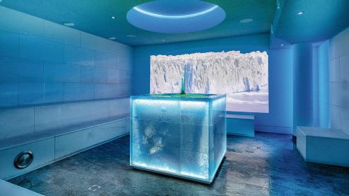 a bathroom with a large glass tank in a room at Aktiv- & Gesundheitsresort das GXUND - Thermeneintritt inklusive in Bad Hofgastein
