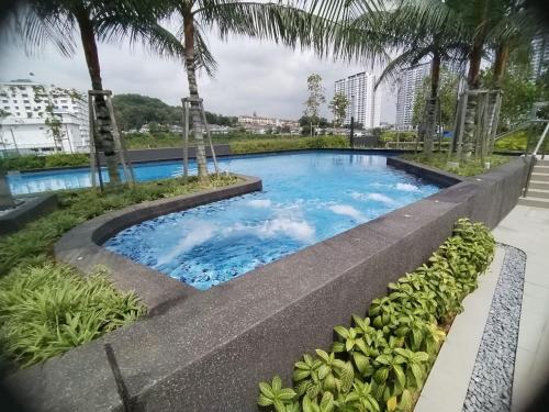 a swimming pool with blue water and palm trees at Japandi Family Play Suite with Slide Bunk Bed in Kajang