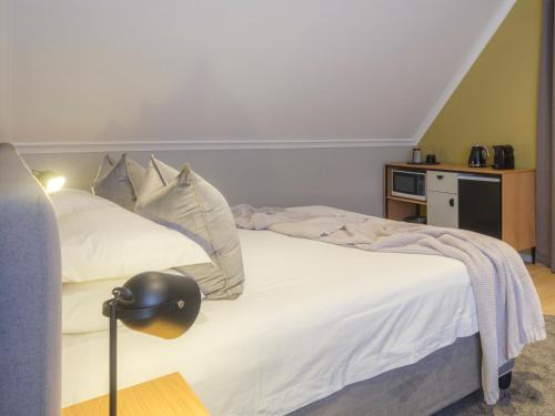 a bedroom with a bed with white sheets and pillows at Sanddrif Stellenbosch Guest Farm in Stellenbosch