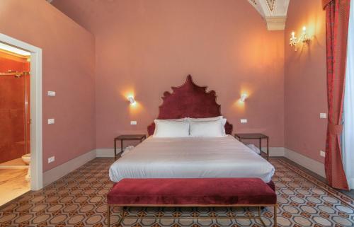 a bedroom with a large bed with a red headboard at Hotel Villa San Michele in Lucca