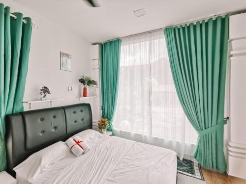 1 dormitorio con 1 cama con cortinas verdes en Inap Idaman 5 With 2 Queen Bed In Kubang Kerian, en Kota Bharu