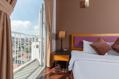a hotel room with a bed and a balcony at Hanoi Golden Sunshine Villa Hotel and Travel in Hanoi