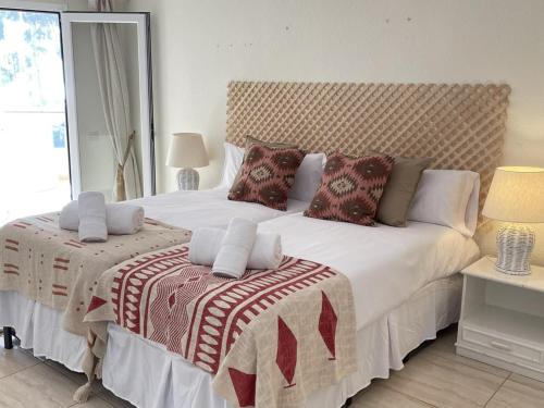 Un dormitorio con una gran cama blanca con almohadas. en Homely Home Marbella Del Mar 5, en Marbella