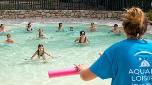 a group of people in a swimming pool at Camping du Lac in Marcillac-la-Croisille