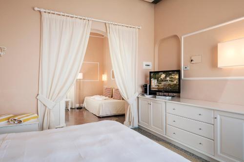 a bedroom with a bed and a television on a dresser at Hotel Helvetia in Sestri Levante
