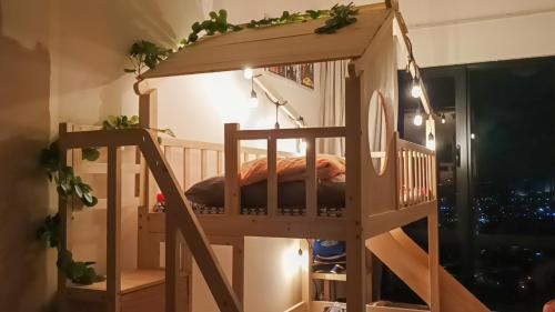 a wooden bunk bed with a ladder in a room at Japandi Family Play Suite with Slide Bunk Bed in Kajang