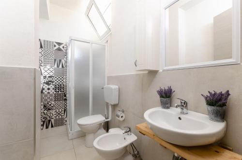 een witte badkamer met een wastafel en een toilet bij Villa Padima in Scicli