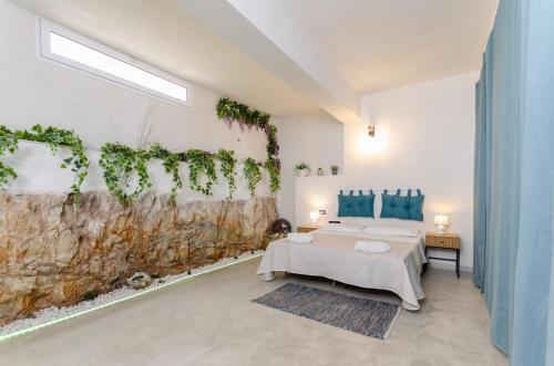 een slaapkamer met een bed en een muur met planten bij Villa Padima in Scicli
