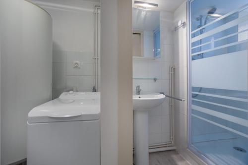 a white bathroom with a sink and a shower at Chalet KOCH in Saint-Pierre-de-Chartreuse