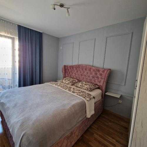 ポドゴリツァにあるStefanijaのベッドルーム1室(ピンクのヘッドボード付きの大型ベッド1台付)