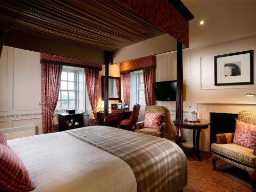 a hotel room with a bed and a desk and chairs at Macdonald Houstoun House in Livingston