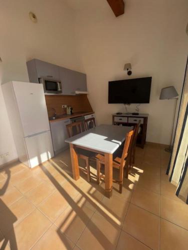 une cuisine avec une table de salle à manger et une télévision dans l'établissement Residence Cap Bleu a Carro, à Martigues